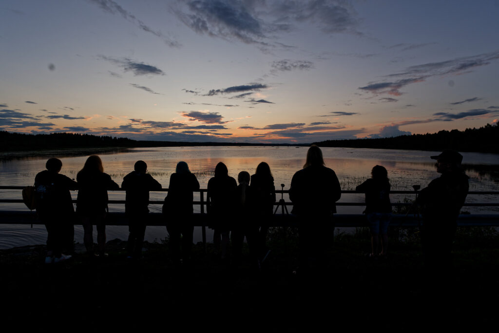 they are standing infront of the lake 